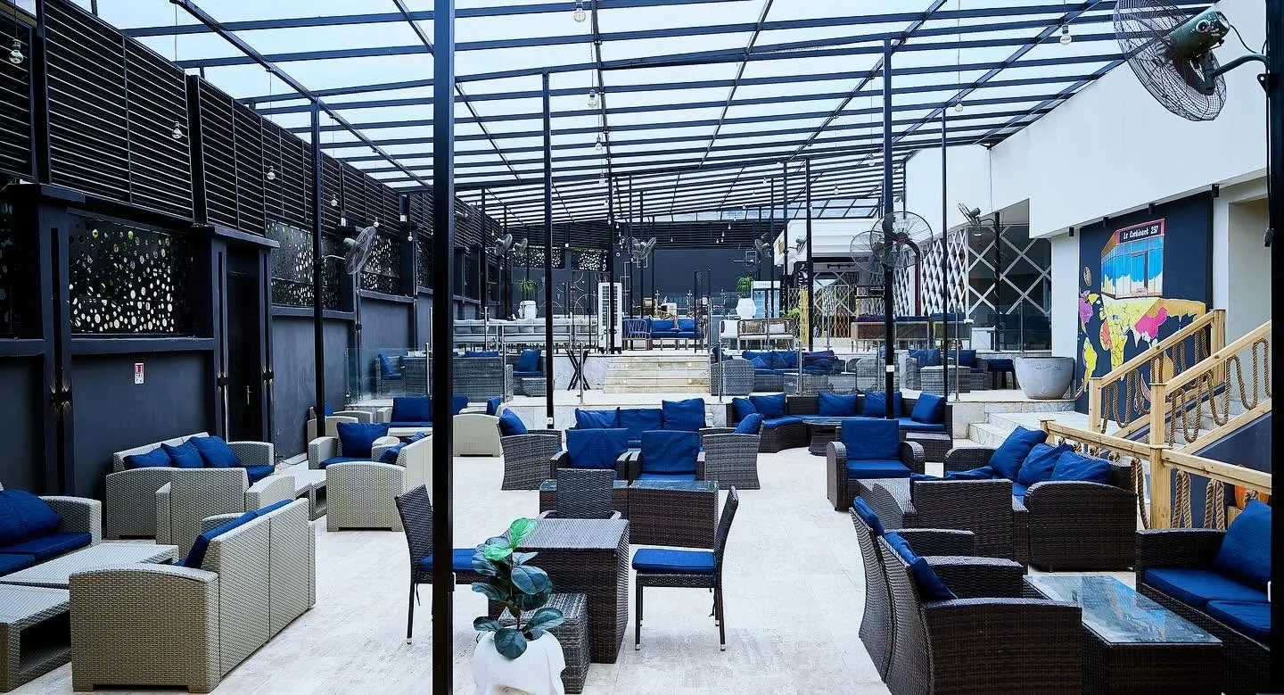 La grande terrasse sous verrière du Continent 237, salons en rotin et coussins bleus